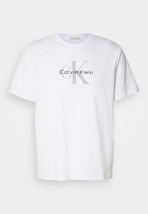Balta kokvilnas T-krekls ar pelēku "Calvin Klein" logotipu, kurā izcelti iniciāļi "ck". Standarta apļa kakla dizains.