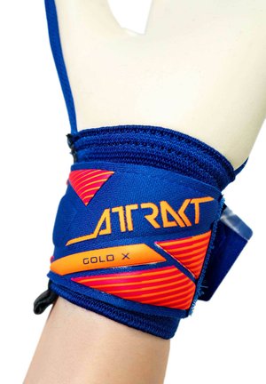 Blauwe en oranje polsondersteuningsband met het label "ATRAKT GOLD X" gedragen om de linkerpols met een witte handschoen.