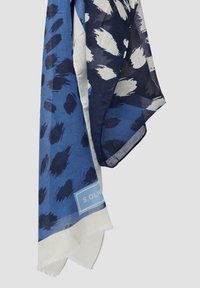 Foulard bleu à motif abstrait avec des nuances variées, doté d'une texture légère et transparente et d'une bordure blanche avec une étiquette de marque.