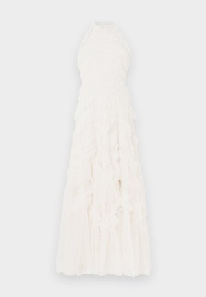 Λευκό φόρεμα με λαιμόκοψη halter, με στρώσεις βολάν, υφασμένο ύφασμα και αέρινο σχέδιο. Μήκος μέχρι τους αστραγάλους με διαφανές επικάλυμμα.