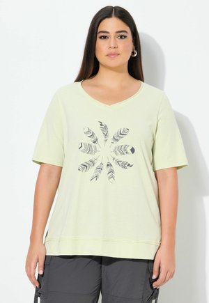 T-shirt vert clair à manches courtes et col en V, présentant un design central de plumes illustrées en noir. Matière douce avec une coupe décontractée.