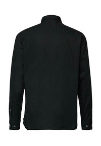 Chemise noire à manches longues avec un col boutonné, présentant une texture de tissu uni et des poignets boutonnés, vue de dos.