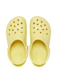 Sabots en plastique jaune avec des trous de ventilation, une semelle intérieure ergonomique et une sangle arrière, présentant une finition lisse et des semelles texturées pour une meilleure adhérence.