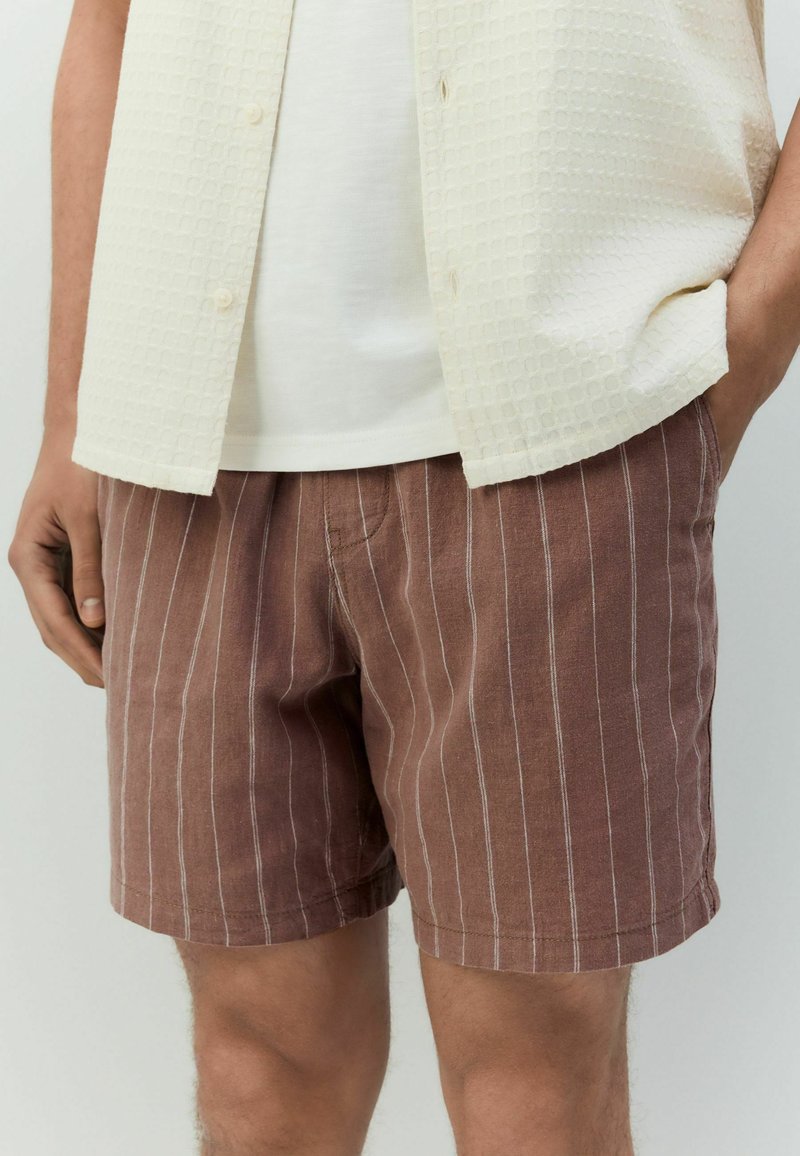 Bruine gestreepte short van lichtgewicht stof, met verticale witte strepen en een relaxte pasvorm, gecombineerd met een textuur crème shirt.