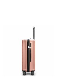 Maleta dura rosa con textura estriada, cremallera negra y asa retráctil. Cuenta con cuatro ruedas para facilitar el movimiento y una cerradura combinada.
