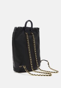 Černý kožený batoh s nabíraným vrchem, zdobený zlatými řetízkovými popruhy a malým vrchním uchem, hladká textura, moderní design.