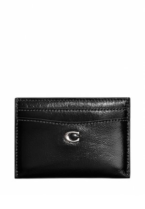 Porte-cartes en cuir noir avec plusieurs emplacements pour cartes et un petit logo métallique argenté au centre sur fond blanc.