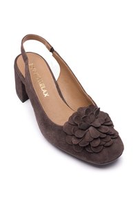 Bruine suède slingback schoen met een textuurrijke bloemaccent op de neus, een afgeronde vorm en een blokhak voor extra stabiliteit.