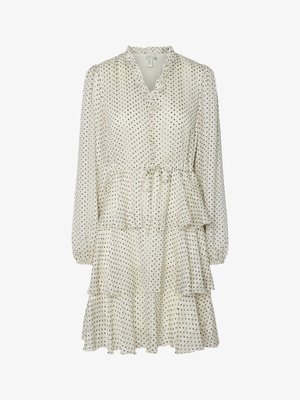 Rochie crem cu buline negre, guler ondulat, mâneci lungi și fustă în straturi. Are talie cu șnur și textură moale a materialului.