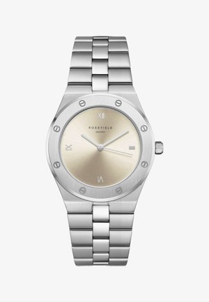 Srebrni ručni sat od nehrđajućeg čelika s bež brojčanikom, rimskim brojkama na pozicijama 12, 3, 6 i 9 te tri tanke kazaljke koje pokazuju 10:10:35.