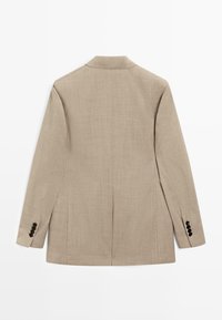 Beige blazer med långa ärmar, skarpt krage, bakventil och svarta knappdetaljer på ärmsluten, visad platt bakifrån.