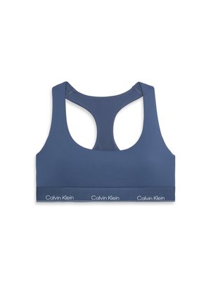 Marinblå sportbehå med racerback-design, tillverkad av ett mjukt material. Har ett logomärkt elastiskt band längs botten.