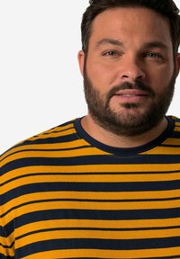 Camiseta a rayas en amarillo y azul marino, hecha de una tela suave. Presenta un cuello redondo y rayas horizontales de diferentes anchos.