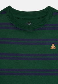 Grün und marineblaue gestreifte Babykleidung mit geripptem Kragen und kleiner brauner Teddy-Bär-Stickerei auf der Brust.
