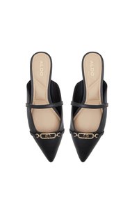 Mules noires à bout pointu avec un dos ouvert, présentant un accent décoratif en chaîne dorée et une finition en cuir lisse. Doublure intérieure beige.