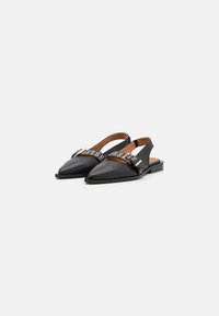 Svarta läderslingback-skor med spetsiga tår, en platt klack och dekorativa silverhål på den breda framremmen.