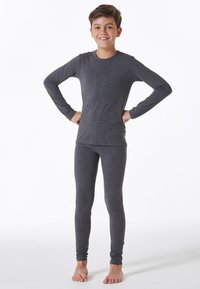 Grå langærmet top og matchende tætsiddende bukser lavet af bomuldsblanding, med rund hals og slim fit, båret uden sko.