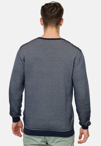 Marineblauw en witte gestreepte trui met een ronde hals, geribde manchetten en zoom, met een textuur gebreid patroon en een ontspannen pasvorm.