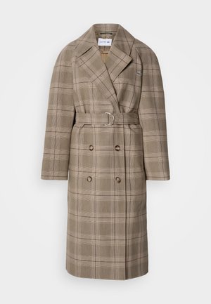 Double-breasted trench coat in tan plaid with a belted waist. Features wide lapels and textured fabric with large buttons.