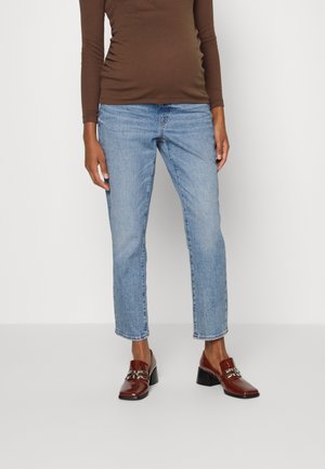 Calças de ganga azul claro com um corte reto e comprimento ligeiramente curto, combinadas com uma blusa de mangas longas castanha e mocassins castanhos brilhantes.