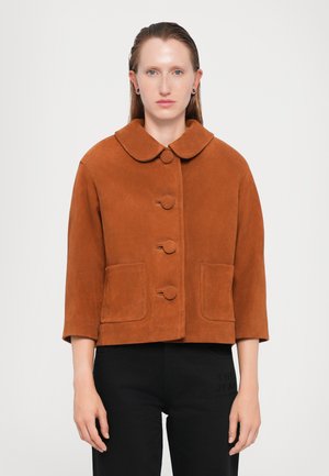 Giacca corta in suede marrone con ampio colletto, tre grandi bottoni e due tasche frontali. Presenta maniche a tre quarti.