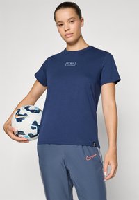 Mørkeblå bomulls T-skjorte med korte ermer, med en hvit "PARIS" logo sentrert på brystet. Akkompagnert av en fotball.