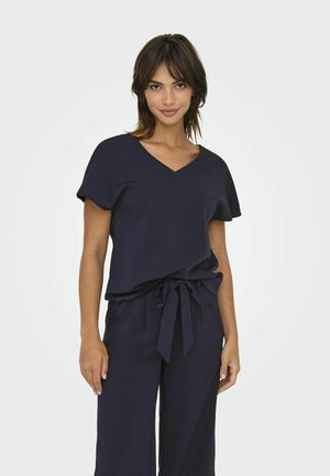 Mörkblå topp med V-ringning, korta ärmar och lös passform, kombinerad med matchande vida byxor och en knytbar midja.