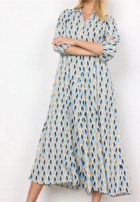 Abito lungo in un tessuto leggero con un motivo ondulato in blu, beige e nero, con colletto e chiusura con bottoni sul davanti.