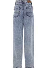 Gaiši zili džinsi ar plašām kāju daļām, redzamas šuves, pieci kabatas un brūns ādas plāksteris pie aizmugurējā jostasvietas. Gluda faktūra.