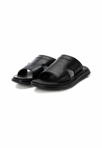 Sandali aperti in pelle nera con punte scoperte, soletta imbottita, suola testurizzata e cinturini curvi. Design semplice con dettagli di cucitura minimi.