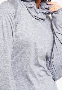 Pullover grigio a maniche lunghe con collo a cascata, realizzato in un tessuto texturizzato. Presenta maniche raglan e una vestibilità morbida.