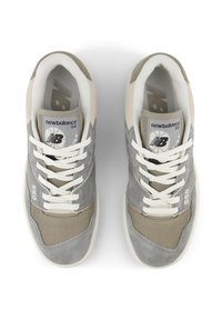 Gray and beige New Balance 550 sneakers with mesh and suede textures, featuring white laces, logo, and 550 branding on the side.
