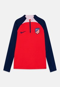 Maglia sportiva a maniche lunghe rossa e blu navy con zip a metà, presenta un logo Nike sulla destra e uno stemma dell'Atletico Madrid rosso, bianco e blu sulla sinistra.