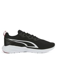 Zapatilla deportiva negra con parte superior de malla, acentos blancos y un tirador rojo. Presenta una suela blanca acolchada y un diseño de cordones.