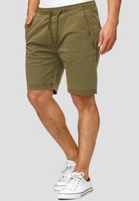 Olivgrüne Baumwollshorts mit elastischem Bund und Kordelzug, Seitentaschen und lässiger Passform, die oberhalb des Knies endet.