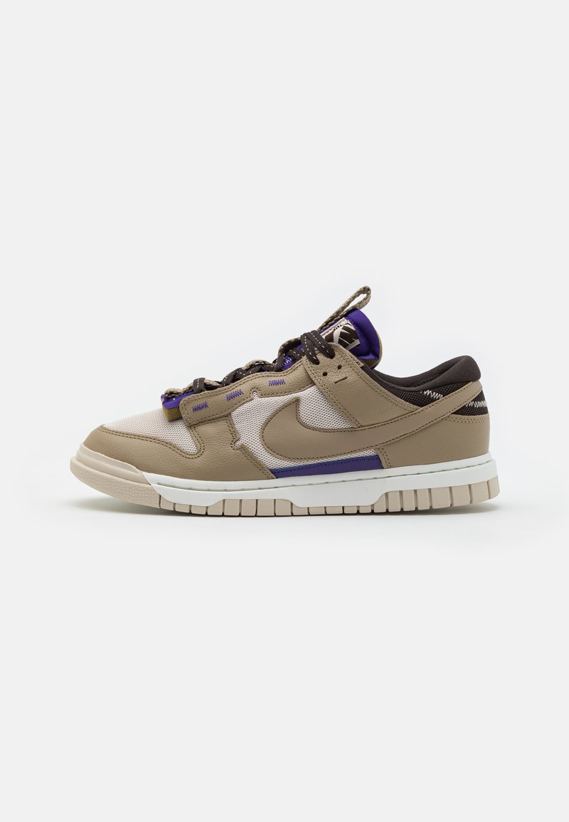 Beige and brown sneaker with a mix of leather and mesh, purple accents, textured surface, and a thick white midsole with a patterned outsole.