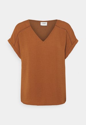 Blouse marron rouille à manches courtes avec col en V, poignets retroussés et détails de couture visibles sur les coutures d'épaule.