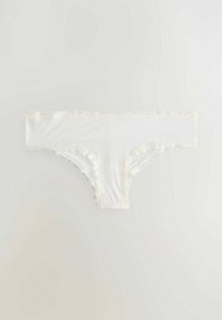 Witte slipjes met kantafwerking, gemaakt van een zachte stof. Ze hebben golvende randen, een eenvoudig ontwerp en een lage tailleband.