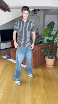 Csíkos szürke póló, rövid ujjakkal, világos kék, bő szárú farmernadrággal párosítva, amelynek a szegélyén csillogó díszítések találhatók. Ezüst cipőt visel.