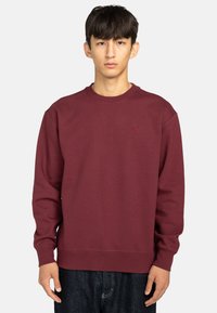 Bordeaux crewneck sweatshirt van zachte stof, met ribgebreide boorden en zoom, en een klein geborduurd logo op de borst. Casual fit.