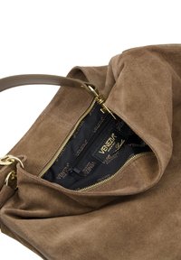Bruine suède handtas met een bovenste ritssluiting en gouden hardware. Het interieur heeft een zwarte voering met logopatronen en een ritsvak.