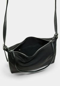 Borsa a tracolla in pelle nera con zip superiore, tracolla regolabile, texture morbida e finitura liscia. Interno spazioso con fodera semplice.