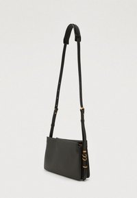 Hallgray nahast risti kehakott, millel on reguleeritav rihm, kuldsed metallosad ja sile tekstuur. Omab lukuga sulgemist ja minimalismi. 