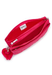 Pink, textured zippered purse with a smooth interior. Features a small colorful pom-pom charm and "Kipling" label inside.