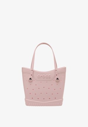Lichtroze Crocs draagtas met meerdere ventilatiegaten, twee handvatten en een logo dat in het midden aan de voorkant is gegraveerd.