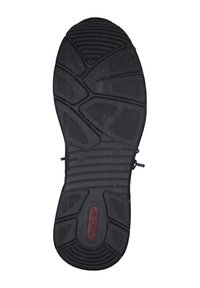 Black rubber shoe sole featuring textured patterns, flex grooves, and a branded logo in red, designed for traction and durability.