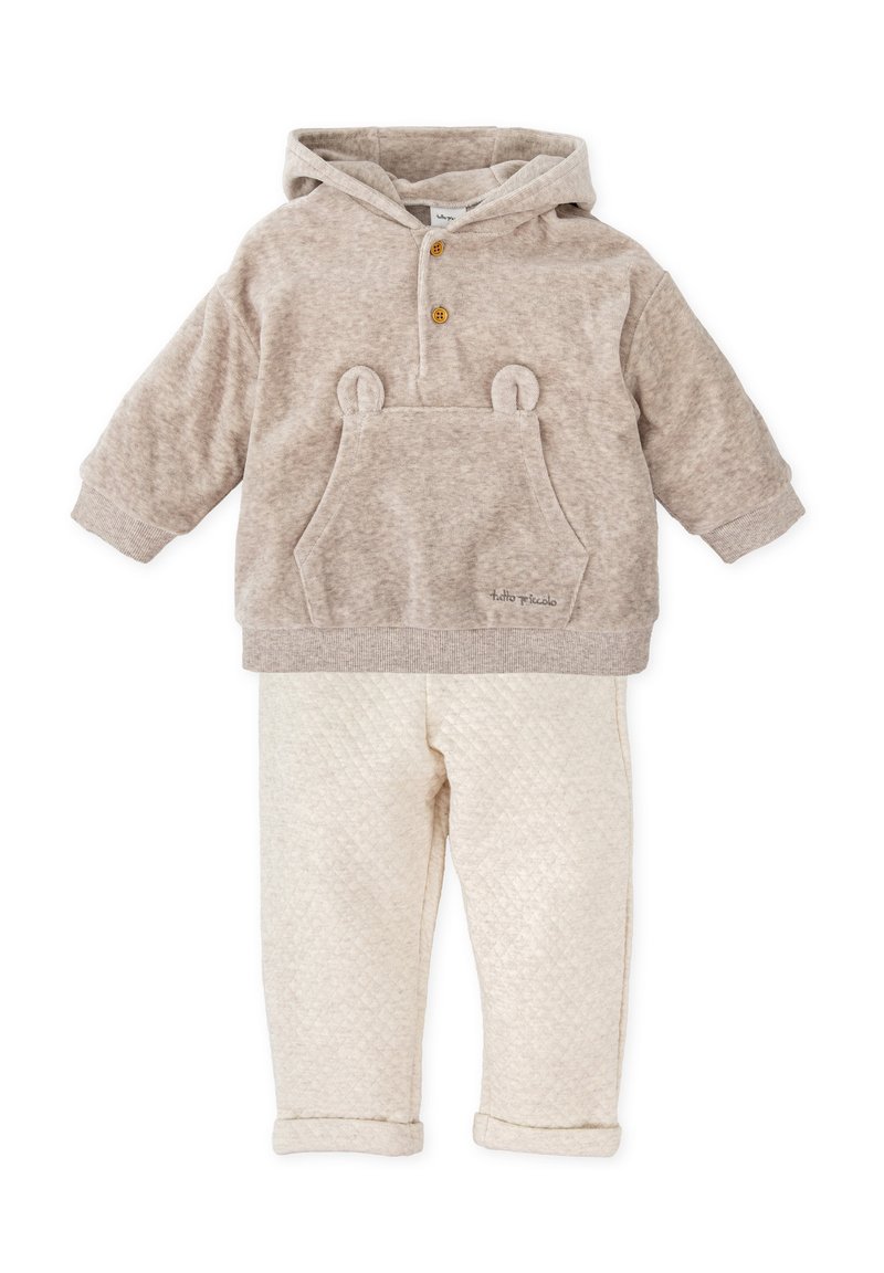 Sudadera con capucha beige con orejas de oso y un bolsillo frontal, combinada con pantalones crema acolchados con manguitos doblados. Textura suave en toda la prenda.