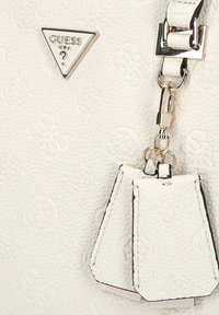 Borsa Guess bianca con texture, motivi in rilievo, logo metallico triangolare e nappine in pelle bianca attaccate da componenti in oro.