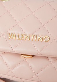 Ραφτό τσάντα χρώματος ροζ από δέρμα με χρυσά αξεσουάρ. Διαθέτει το ανάγλυφο λογότυπο "VALENTINO" και ένα γεωμετρικό ραμμένο σ�χέδιο.