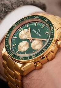 Gouden chronograaf horloge met een groene gestructureerde wijzerplaat, gouden subdials en een gouden metalen band. Beschikt over een tachymetrische schaal en duidelijke markeringen.